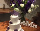 Bruidstaarten - Witte stapel met paarse en lila roosjes en vlinders